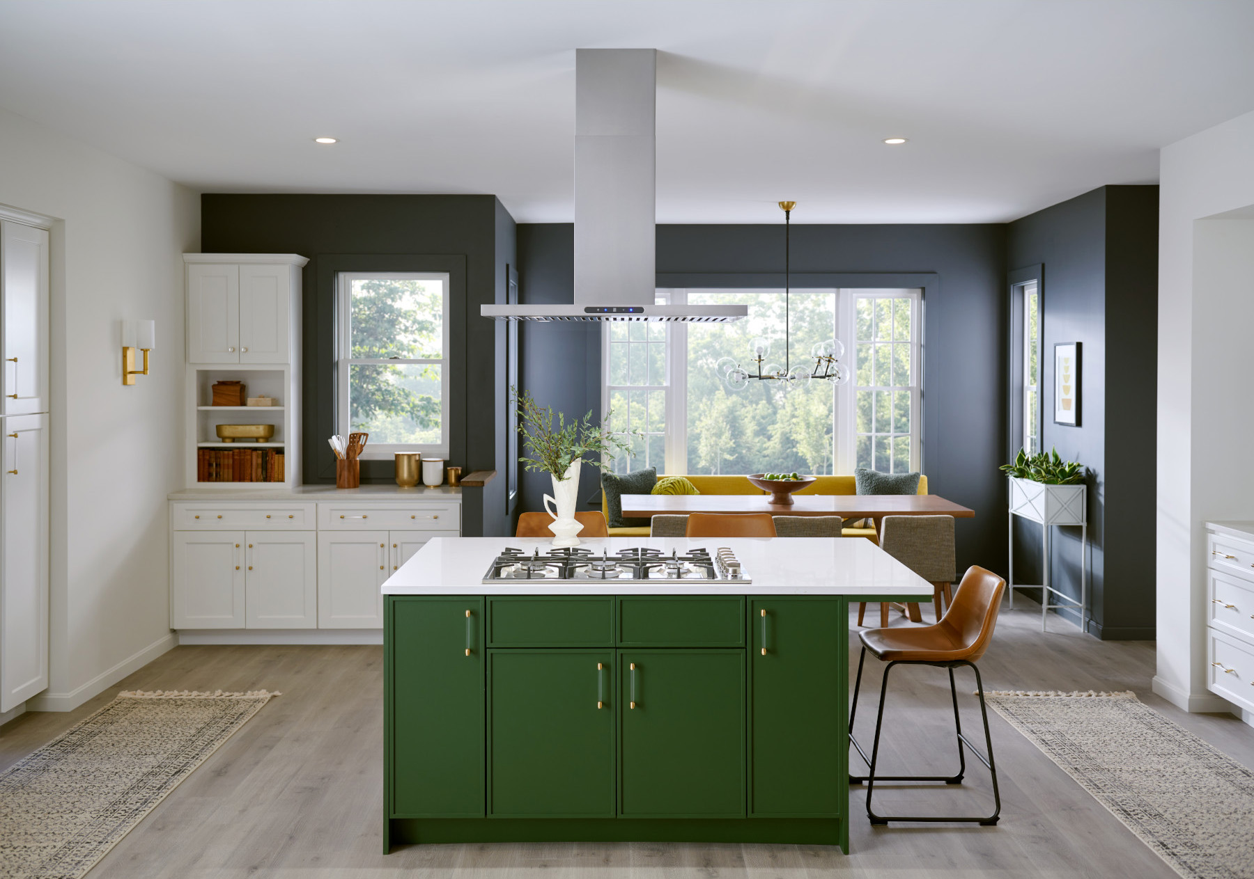 Island range hood installed above an island cooktop in an open concept kitchen